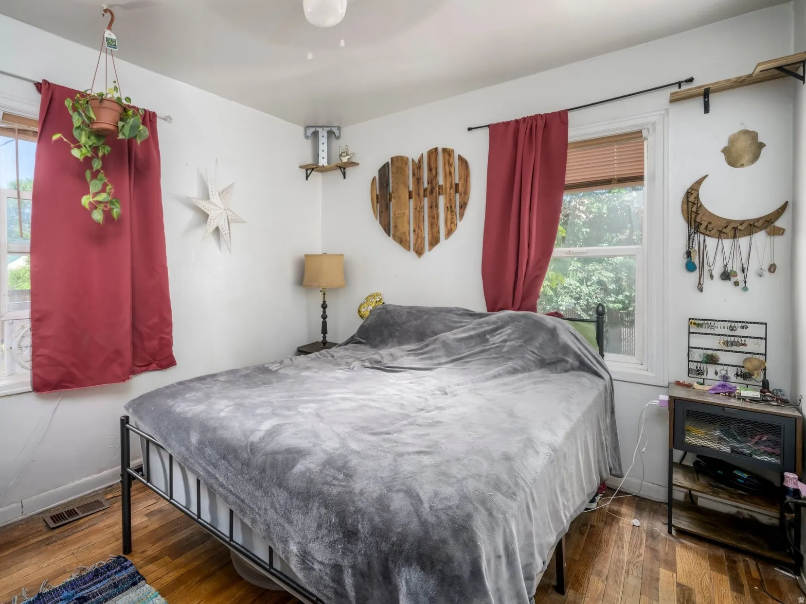 Bedroom featuring wood-finish flooring, two windows, and a ceiling-mounted light fixture