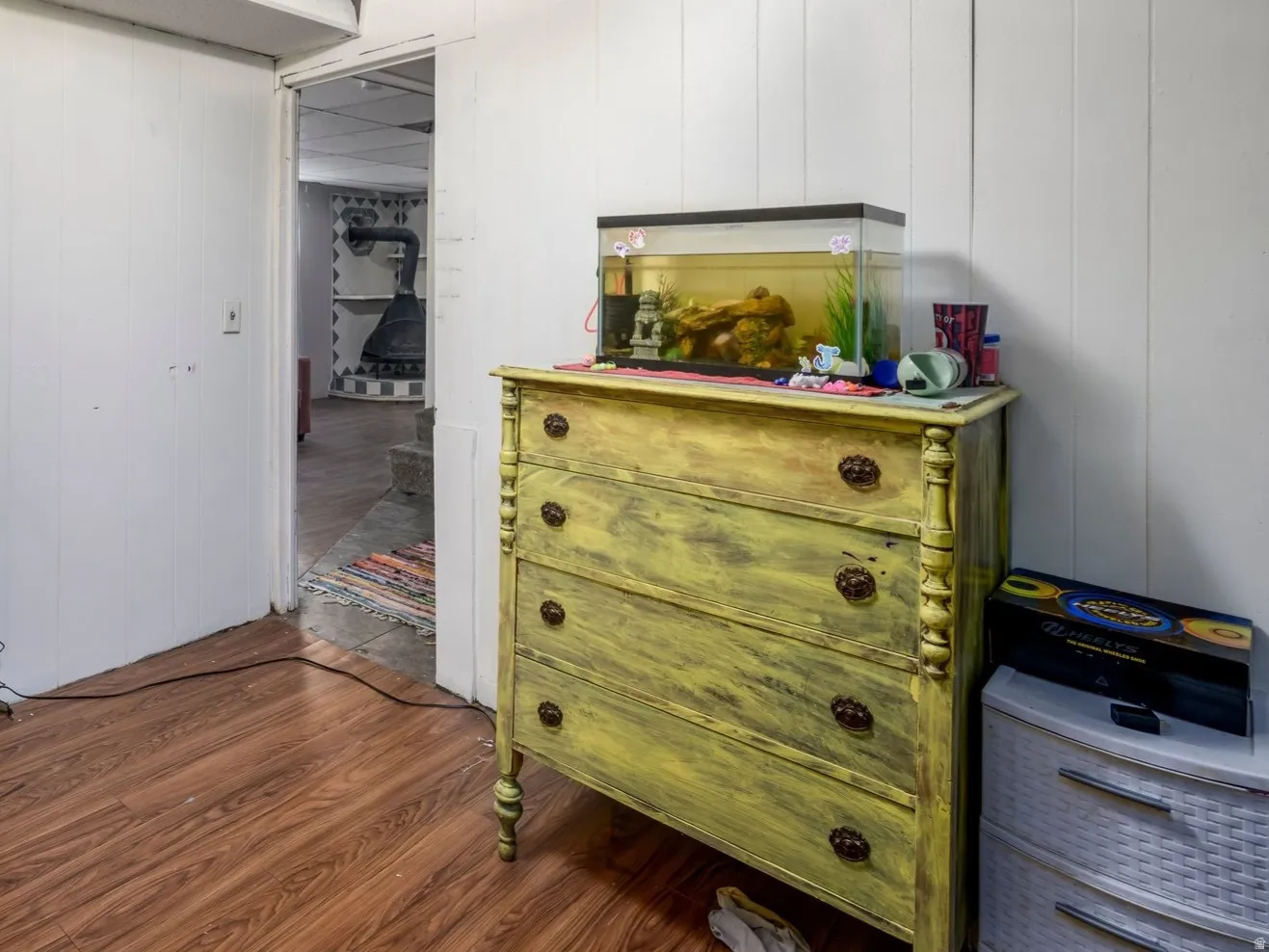 Room featuring wood-finish flooring, white paneled walls, and a drop ceiling with recessed lighting