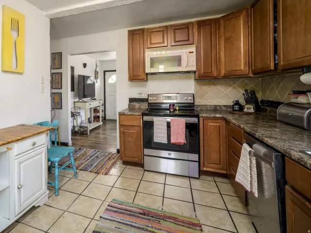 Kitchen featuring wood-finish cabinetry, stainless steel appliances, and a tile backsplash