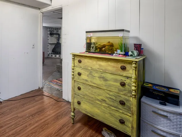 Room featuring wood-finish flooring, white paneled walls, and a drop ceiling with recessed lighting