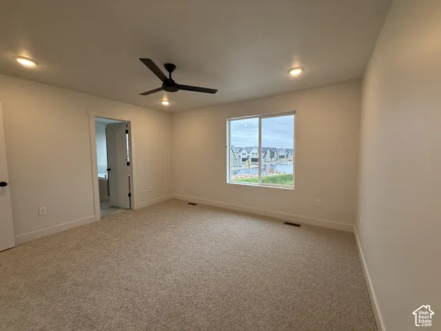 Neutral-toned carpeting, recessed lighting, and a modern ceiling fan
