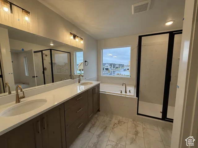 Dual vanity with under-mount sinks, a built-in soaking tub, a separate shower with a black-framed enclosure, and marble-look tile flooring