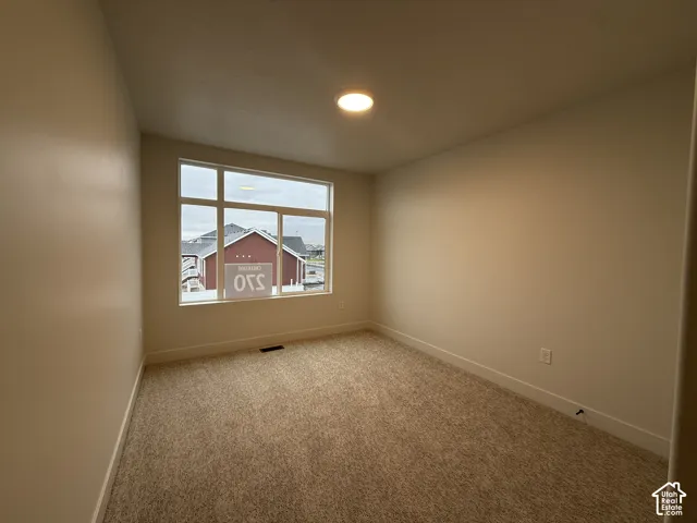 Recessed lighting fixture, neutral wall paint, carpet flooring, and a multi-pane window