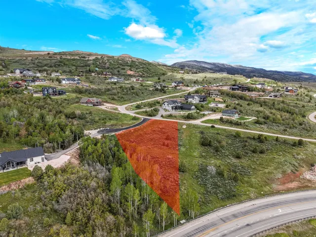 Expansive undeveloped land parcel featuring mature trees, a gently sloping topography, and partial mountain terrain