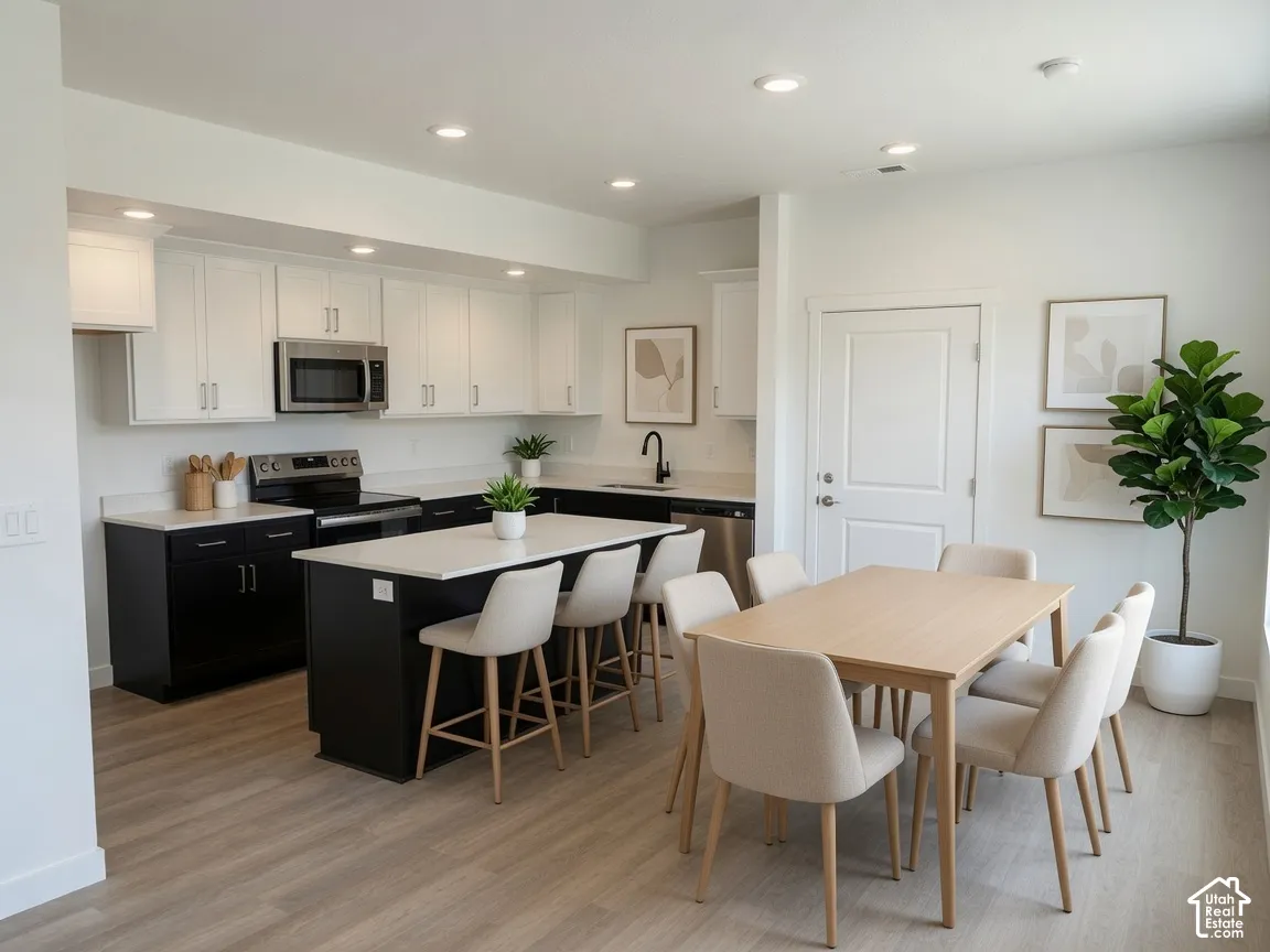 Modern kitchen and dining area featuring light wood-finish flooring