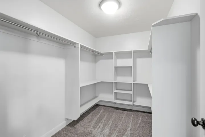 Walk-in closet featuring built-in shelving, multiple hanging rods, corner shelving, and recessed lighting