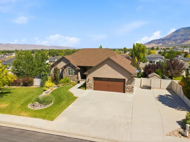 Stucco and stone facade property featuring a two-car garage with a brown door
