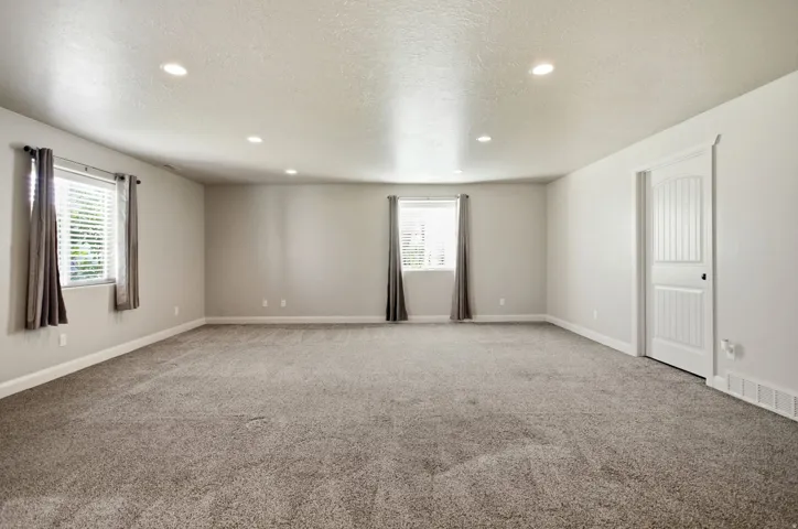 Spacious room featuring neutral carpeting and light gray wall paint