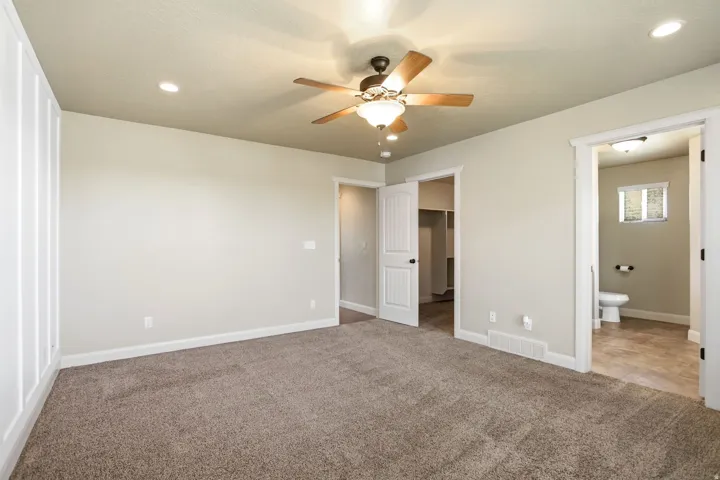 Carpeted room featuring a ceiling fan with integrated lighting, recessed lighting, white baseboards, and a built-in closet with shelving