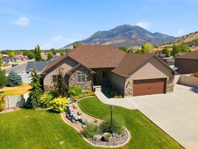 Crafted exterior featuring stone and stucco accents, a brown shingle roof, and an attached two-car garage