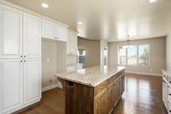 Kitchen featuring a large central island with a granite countertop and wood-finish cabinetry