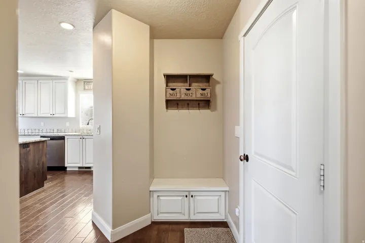 Entryway featuring a built-in bench with cabinet storage and wood-finish flooring