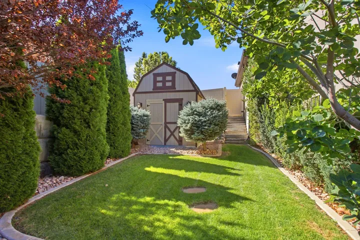 Expansive green lawn with a charming barn-style shed