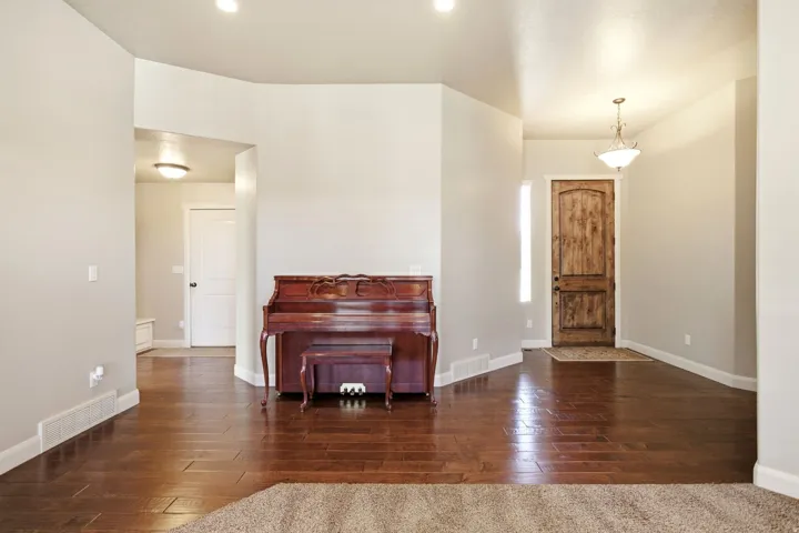 Entryway with wood-finish flooring, a rustic wood front door, and a decorative pendant light fixture