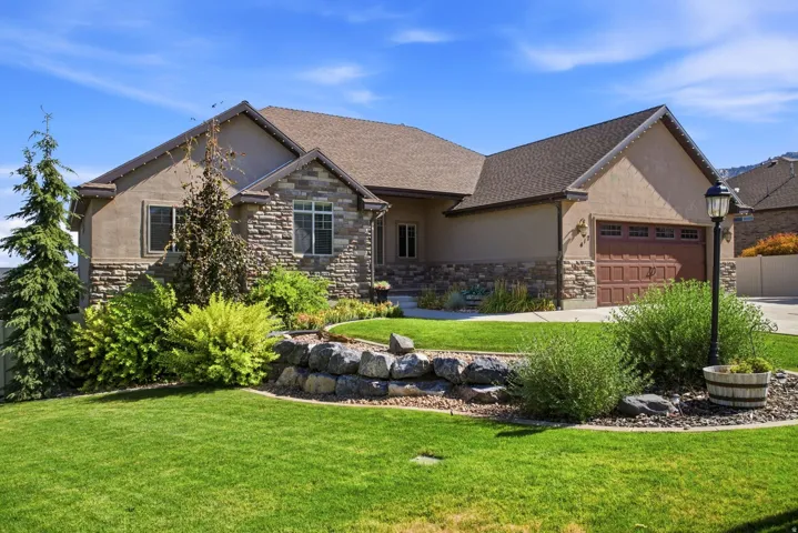 Stucco and stone exterior featuring a two-car garage