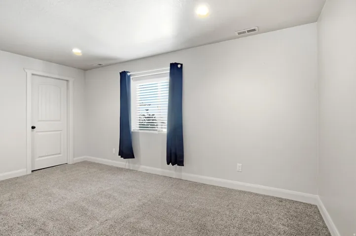 Neutral wall paint, recessed lighting, and grey carpet flooring