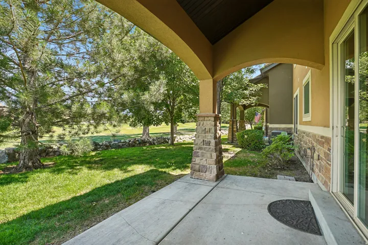 Covered patio featuring a concrete slab and stone-clad support columns