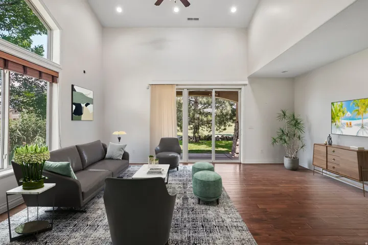 Living area with vaulted ceilings, recessed lighting, and wood-finish flooring