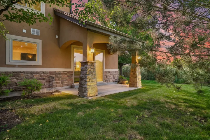 Covered patio featuring stone pillars and wall sconces