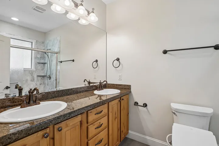 Dual vanity featuring integrated sinks and bronze-finish faucets, set within a granite-finish countertop