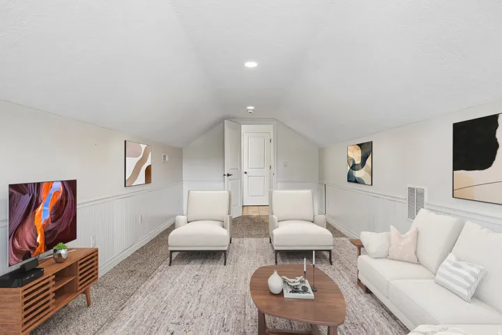 Finished attic space featuring sloped ceilings, white paneling, and wall-to-wall carpeting