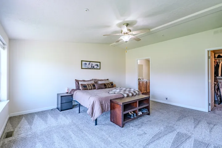 Expansive carpeted room featuring a ceiling fan, a window, and a built-in closet