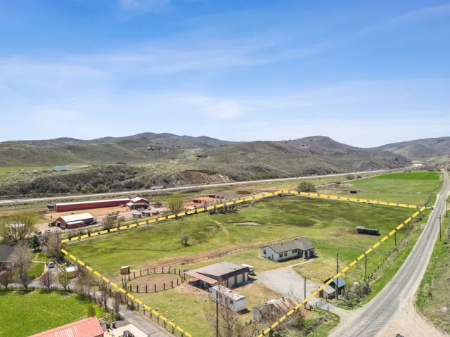 Expansive rural property featuring a primary residence, multiple outbuildings, and a round pen