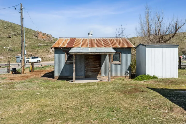 Corrugated metal siding old hay barn and water well house