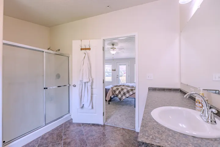 Single vanity with a polished chrome faucet, under-mount sink, and a dark countertop