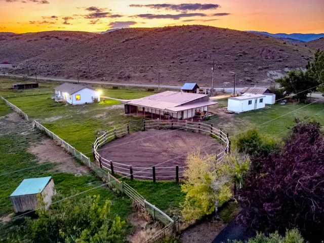 Expansive property featuring a circular fenced arena with a loose dirt surface