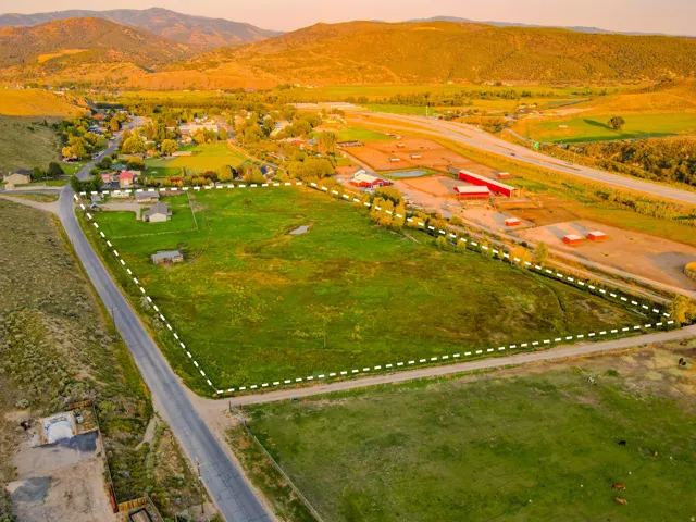 Expansive acreage featuring green pastures, a natural pond, and direct road frontage