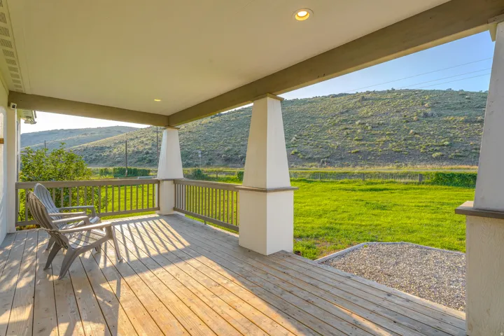 Covered porch featuring wood plank flooring and a railing system