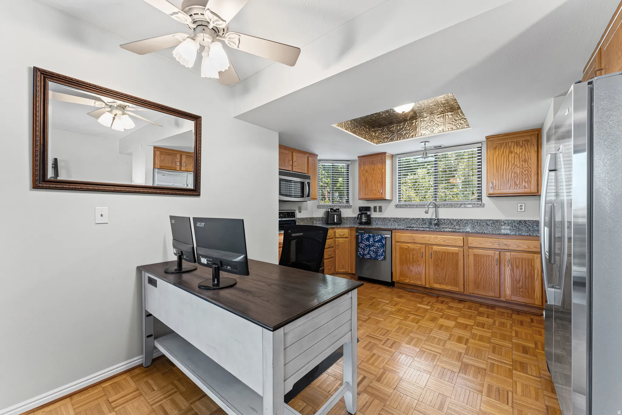 Kitchen featuring wood-finish flooring, natural wood cabinetry, and stainless steel appliances