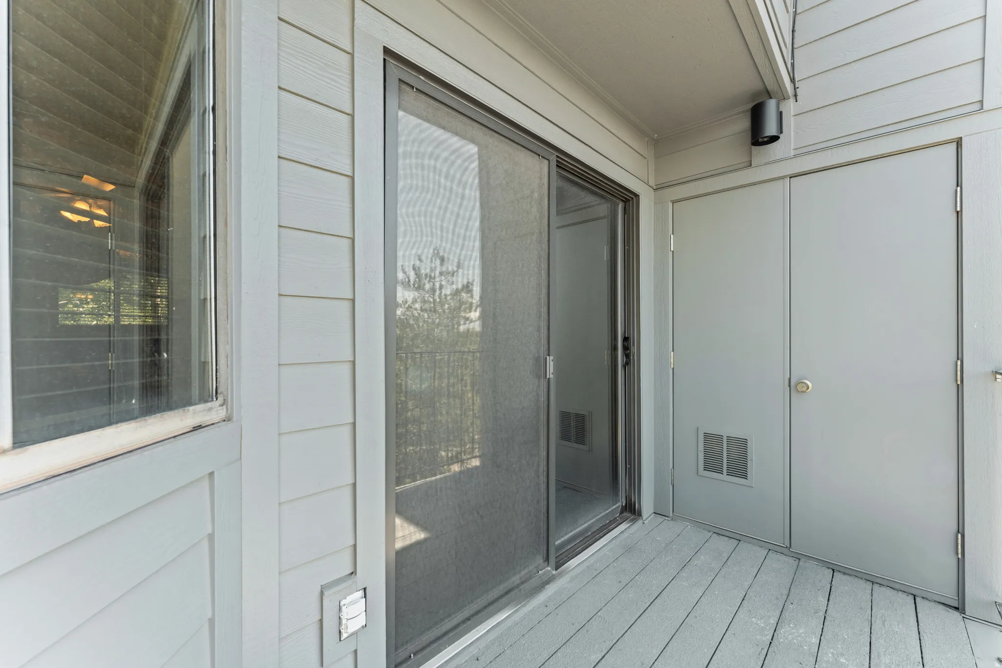 Private outdoor patio featuring wood-finish decking and neutral siding