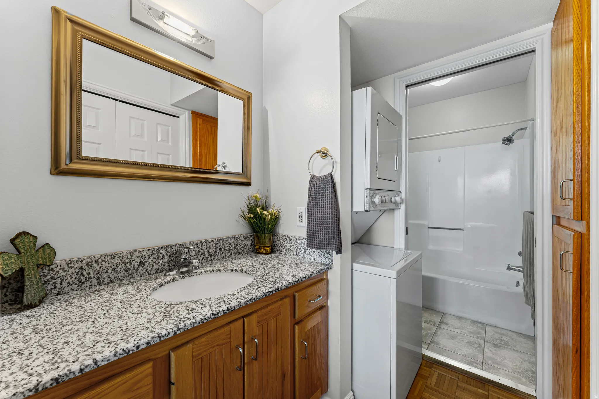 Bathroom featuring a vanity with granite-style countertop, integrated sink, and wood-finish cabinetry