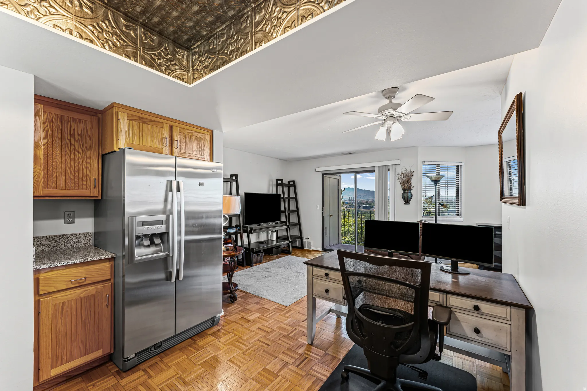 Kitchen area with wood cabinetry and a stainless steel refrigerator