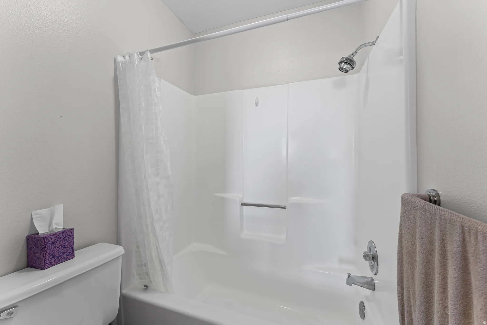 White acrylic tub/shower combination featuring chrome fixtures