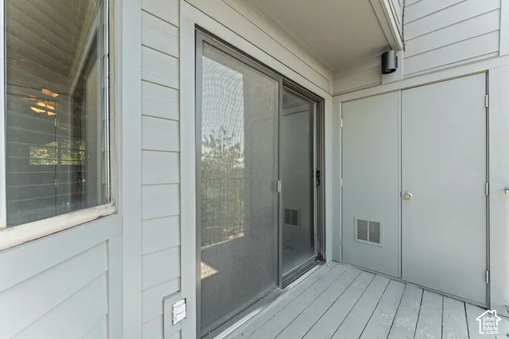 Private outdoor patio featuring wood-finish decking and neutral siding