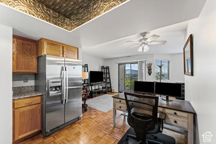 Kitchen area with wood cabinetry and a stainless steel refrigerator