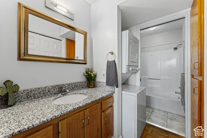 Bathroom featuring a vanity with granite-style countertop, integrated sink, and wood-finish cabinetry