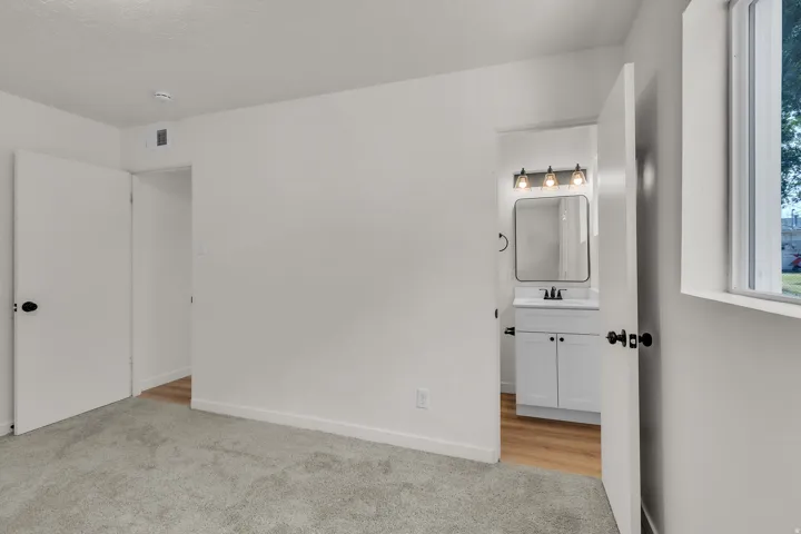 Spacious room with light gray carpeting and white walls
