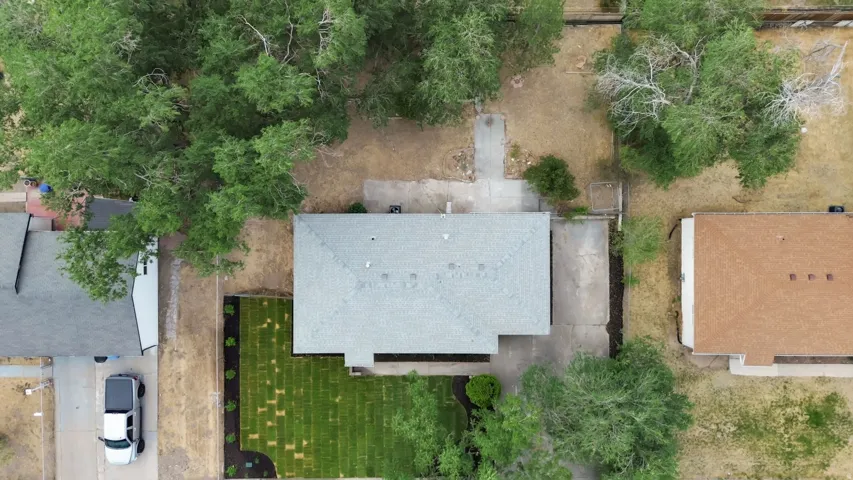 Single-story residence featuring a gray shingle roof and an attached concrete driveway
