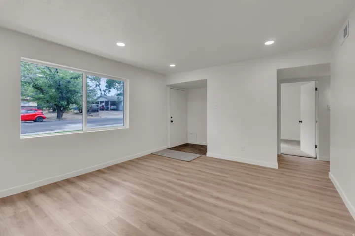 Bright living space featuring light wood-finish flooring, recessed lighting, and a large window