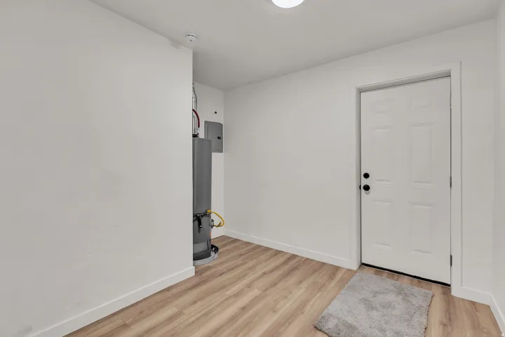 Entryway featuring wood-finish flooring and a white paneled door with black hardware