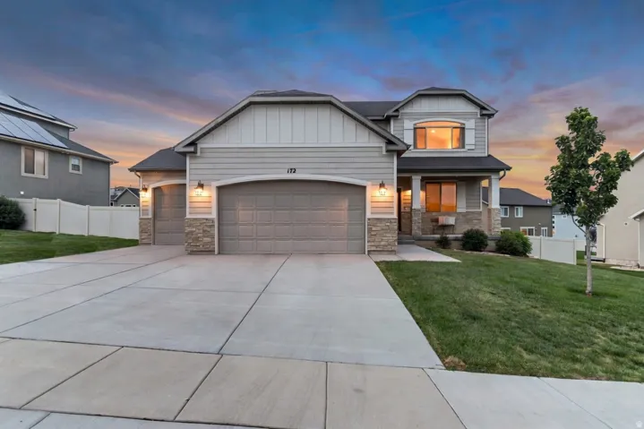 Contemporary two-story residence featuring light gray siding and stone accents