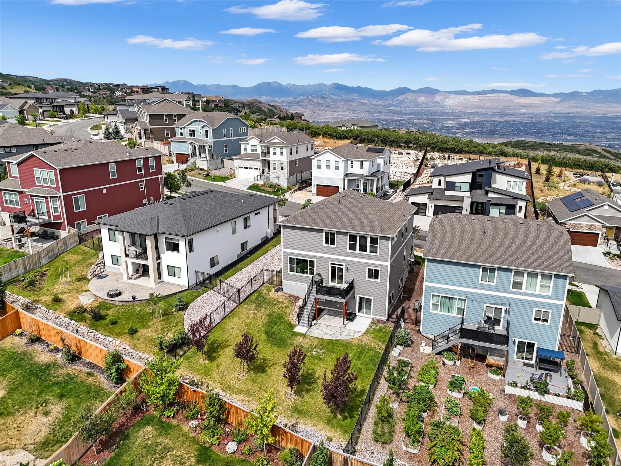 Contemporary residential community with varied architectural styles, showcasing mountain and distant city landscapes