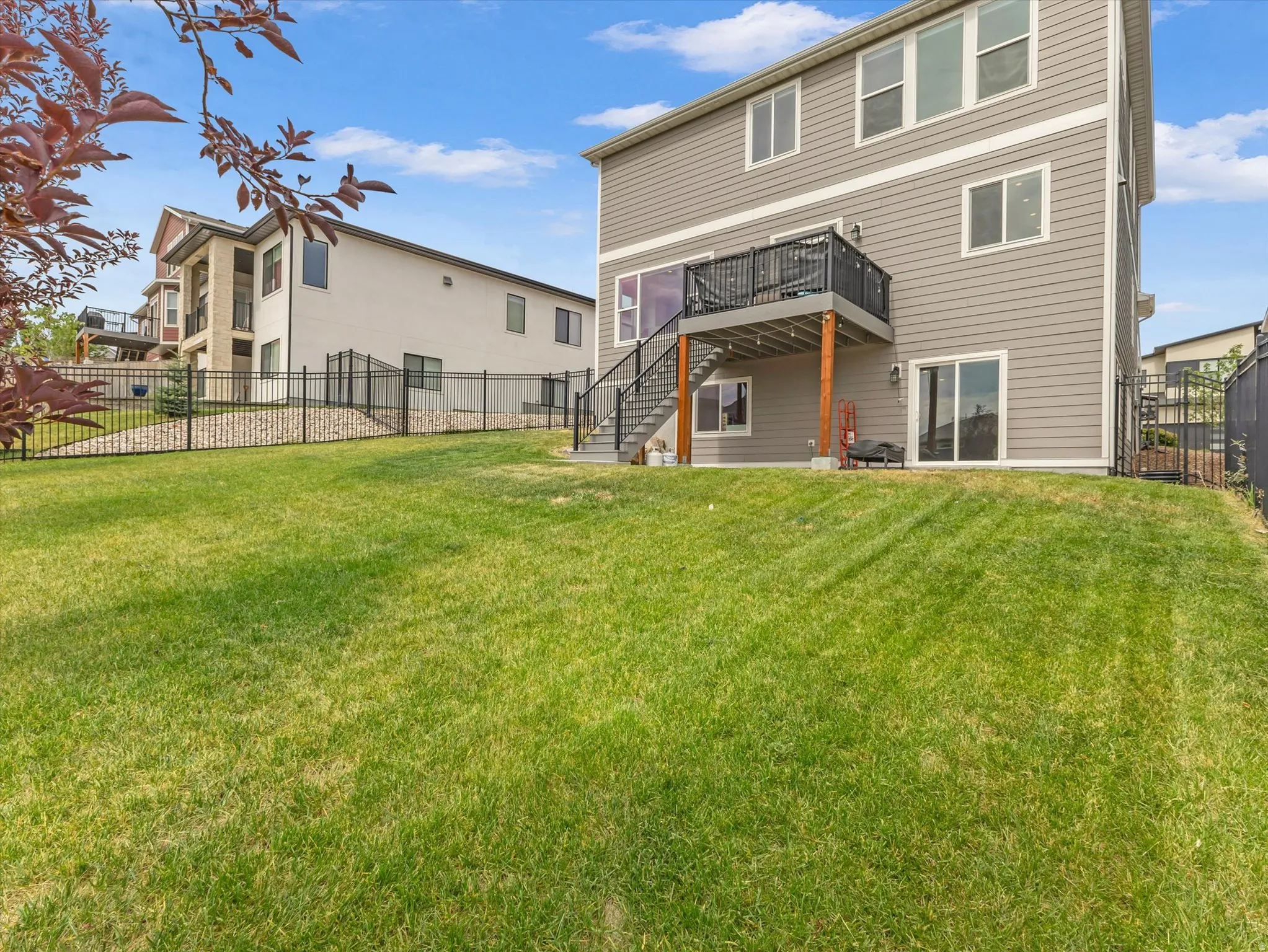 Spacious sloped lawn with a multi-level gray-sided residence
