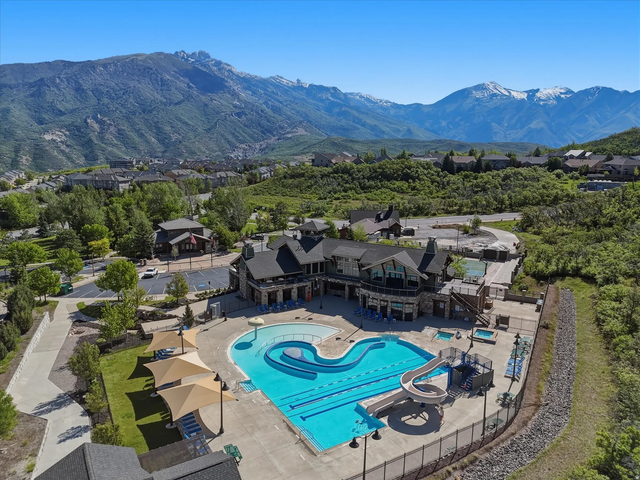 Community clubhouse with multiple swimming pools, water slide, and two hot tubs