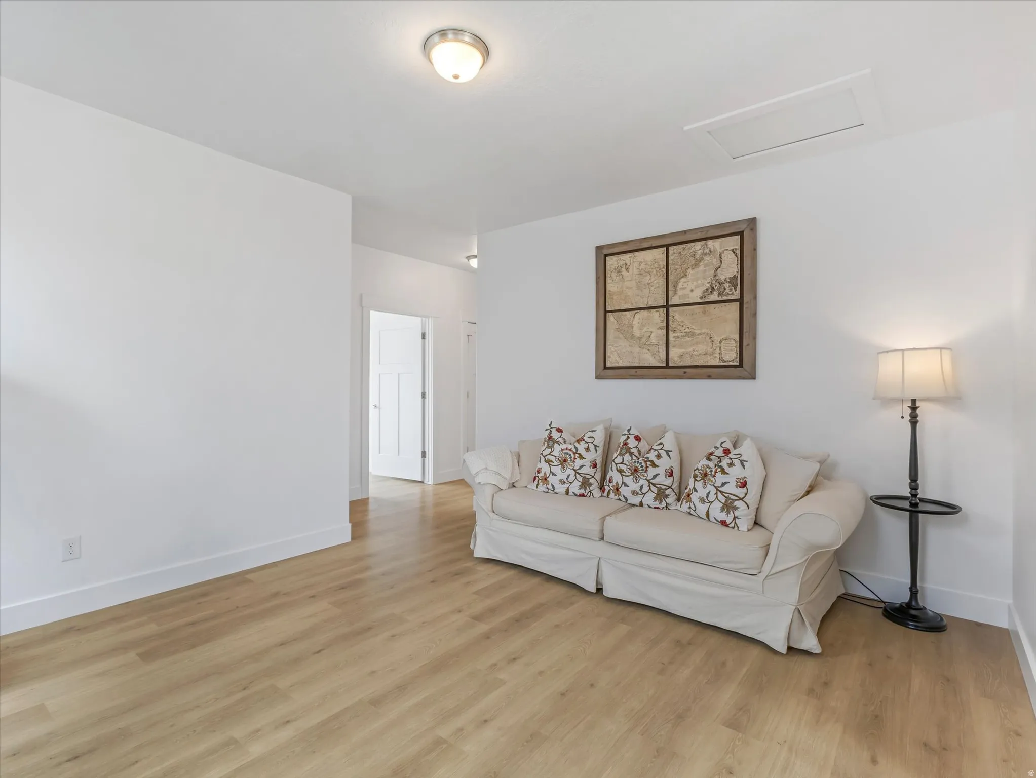 Bright interior space featuring light wood-finish flooring, white baseboards, and neutral wall tones