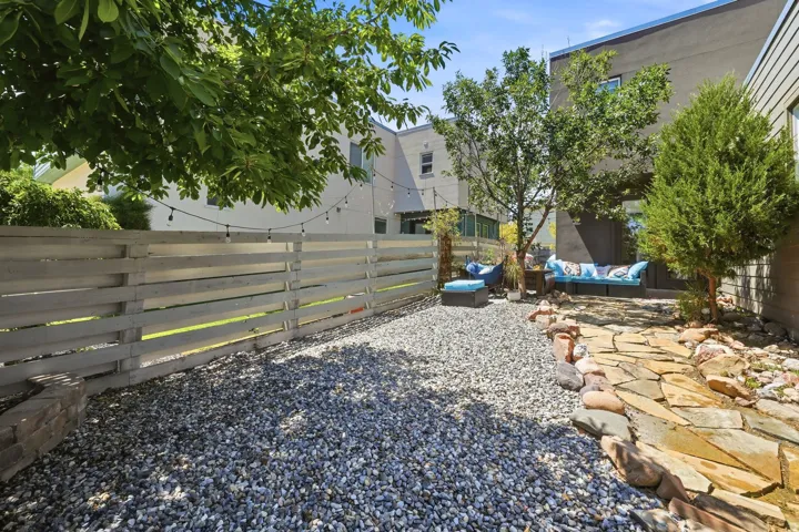 Private outdoor space featuring a flagstone pathway, gravel landscaping, and mature trees